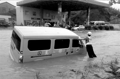 女交警雨中撐側(cè)傾校車(chē) 受訪稱(chēng)不應(yīng)突出個(gè)人（圖）