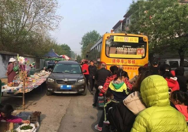 青州這所學校門口全是擺攤的，校車都堵了...