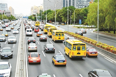 西二環(huán)主路，幾輛黃色校車列隊行駛供圖/CFP