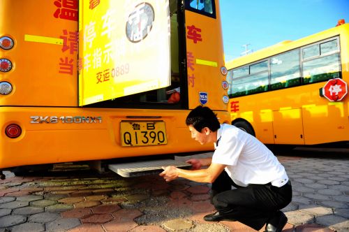 交運溫馨校車黃島分公司一名駕駛員在檢查校車逃生門設置。